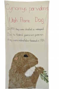 Utah Prairie Dog by Cory S, Danny E, Dejie Z, and Joan Y,  Ms Rabina's 6th grade class 2013. Faux fur, fabric, and ribbon applique, with hand lettering. 