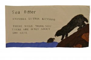 Sea Otter by Natalie, Saul, Riccardo and Olinga. Ms Harada's 6th grade class, Thomas Starr King Middle School, 2013. Fabric and faux fur applique with rubber stamps, and string.